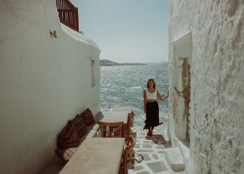 A girl in a flowy skirt and top standing near water