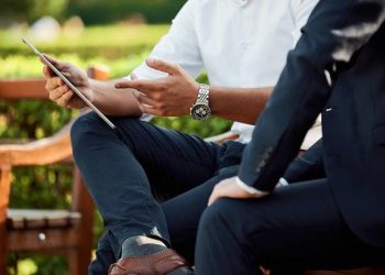 Two businessmen going over self service BI tools using a tablet