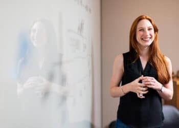 Female professional teaching coworker how to maximize the workday and boost productivity during team discussions. (Work Day)